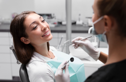 หญิงสาวนั่งที่คลินิกทันตกรรมกำลังพูดคุยกับทันตแพทย์